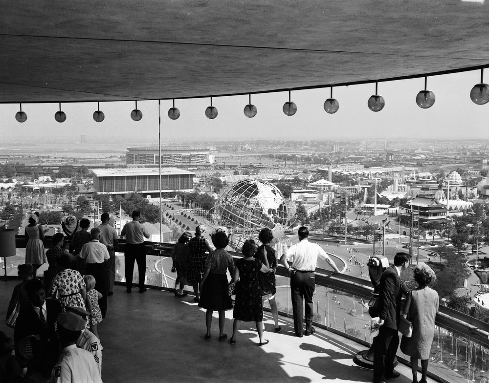 Visitors on the observation deck of the New York State Pavilion looking out over the 1964 World's Fair and its Unisphere.