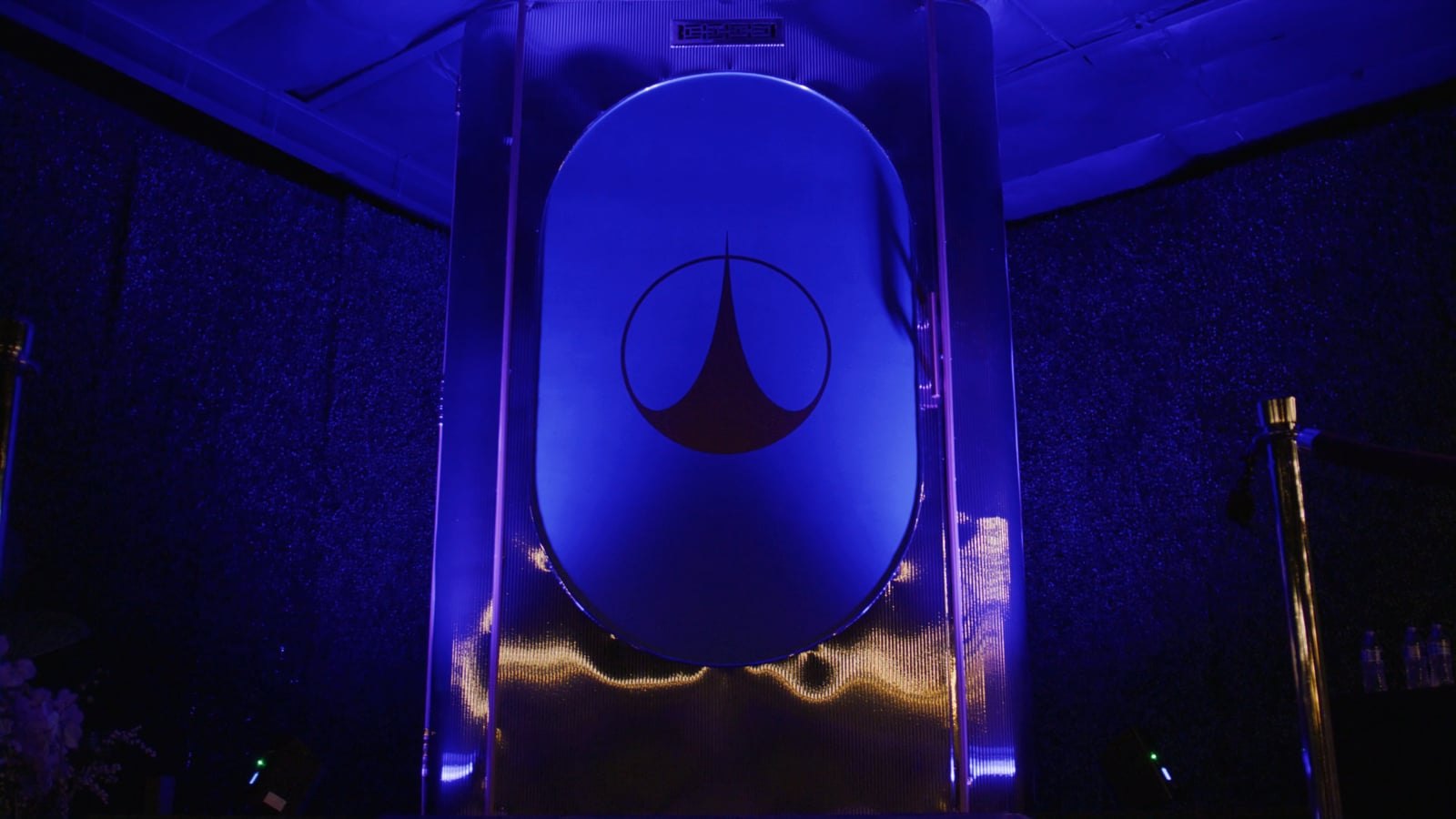 The One World 2087 space elevator, lit blue, with its door closed