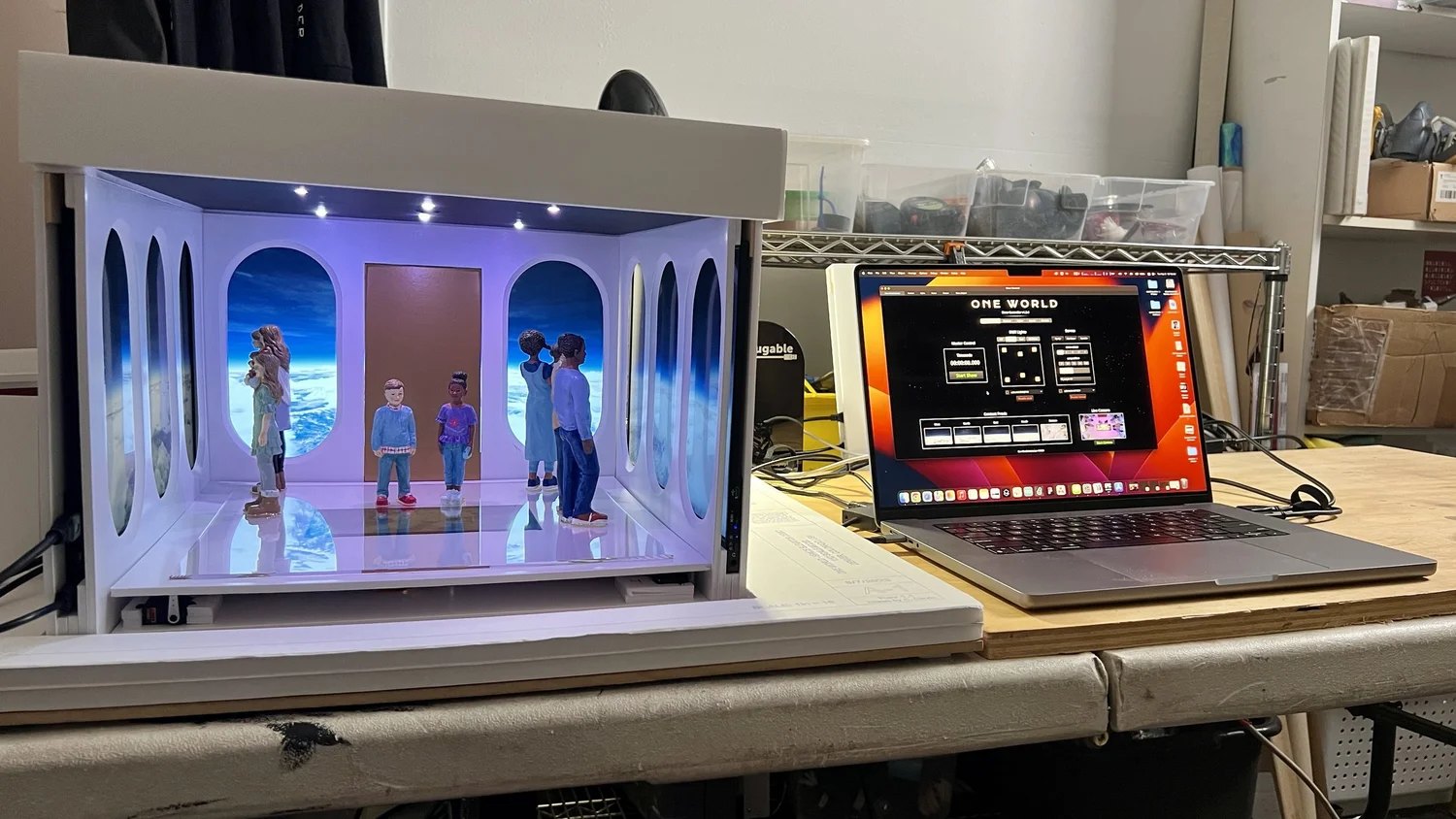 The 1:12 scale model of the elevator beside the laptop running its show
